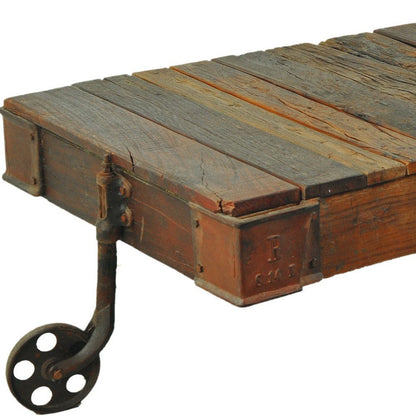 50" Brown and Black Solid Wood and Iron Distressed Wheel Coffee Table